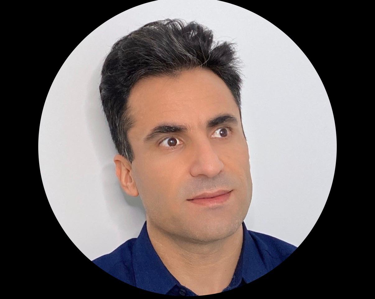 Mehdi Dana, Advocacy AI team member, in a dark blue collared shirt against a plain light background, portrait cropped in a circular frame with black border.